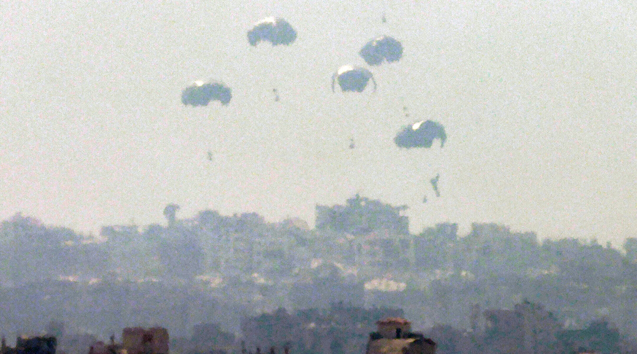 Humanitarian aid is dropped on the Gaza Strip as pictured from a position along the border in southern Israel on July 27, 2025.