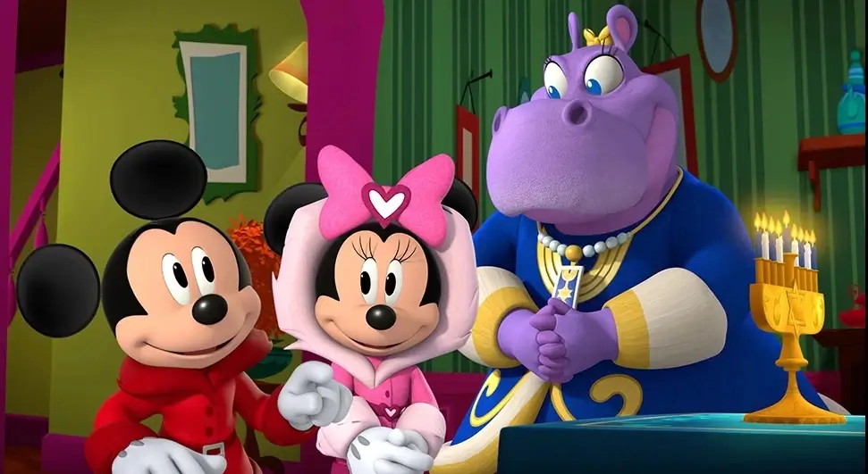 A still from the episode “Nochebuena at the Funhouse / Hanukkah at Hilda’s. Hilda's hands are covering the ichthys, commonly known as a Jesus fish.