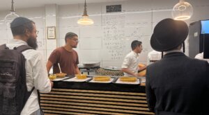 A diner buys cholent at Cholent on the Roof in Geula, Jerusalem, on July 10, 2025.