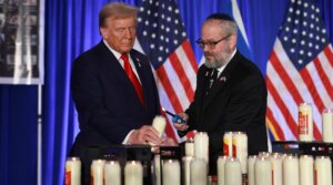 Donald Trump and Yehuda Kaploun light a candle during an Oct. 7 remembrance event at the Trump National Doral Golf Club in Doral, Florida on Oct. 07, 2024. (Joe Raedle/Getty Images)