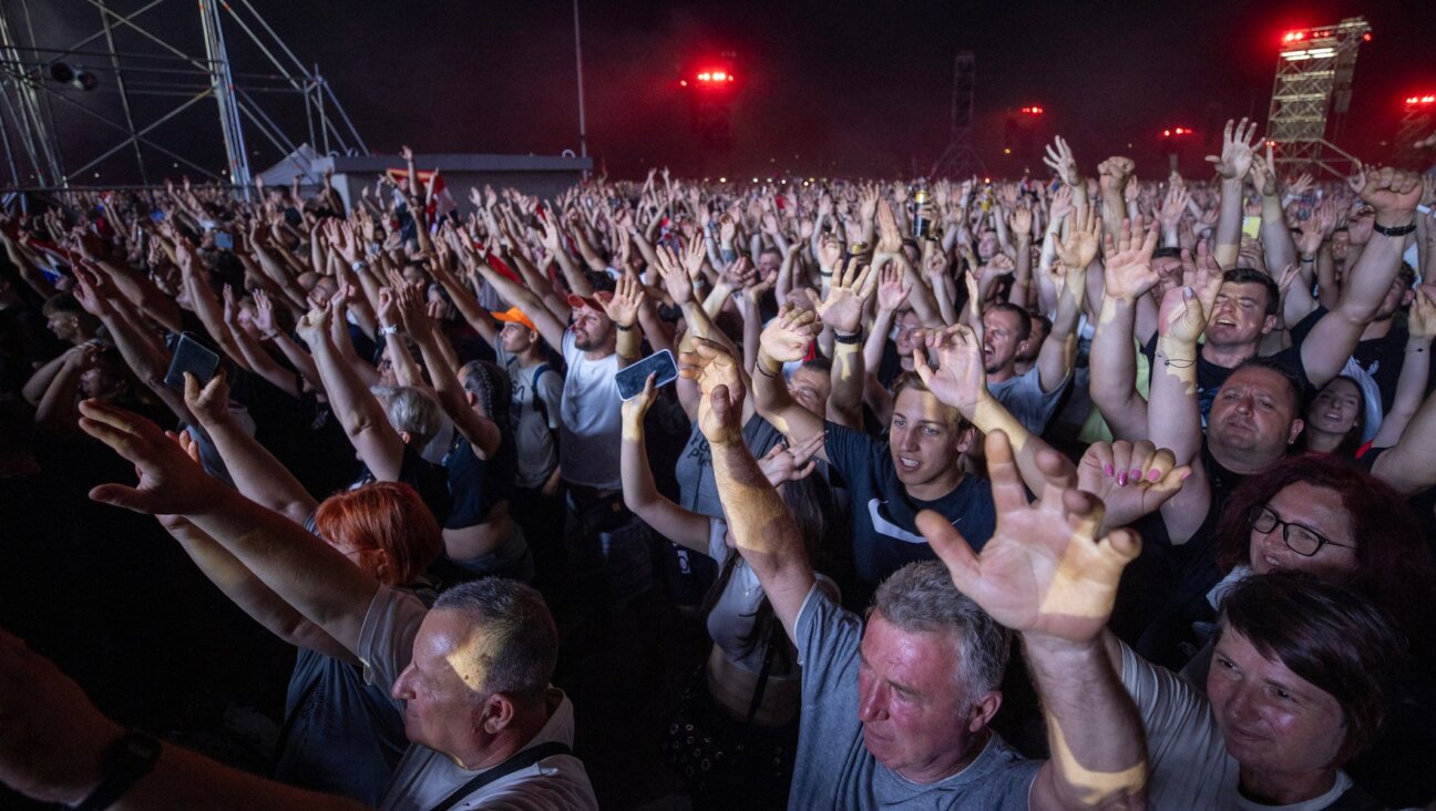 Fans of Croatian nationalist singer Marko Perkovic Thompson gather at the Zagreb hippodrome during a concert by the singer, who is known for his sympathies for the country’s World War II Nazi-allied regime, to an expected by a crowd of some 450,000 people, in Zagreb, on July 5, 2025. (DAMIR SENCAR / AFP)