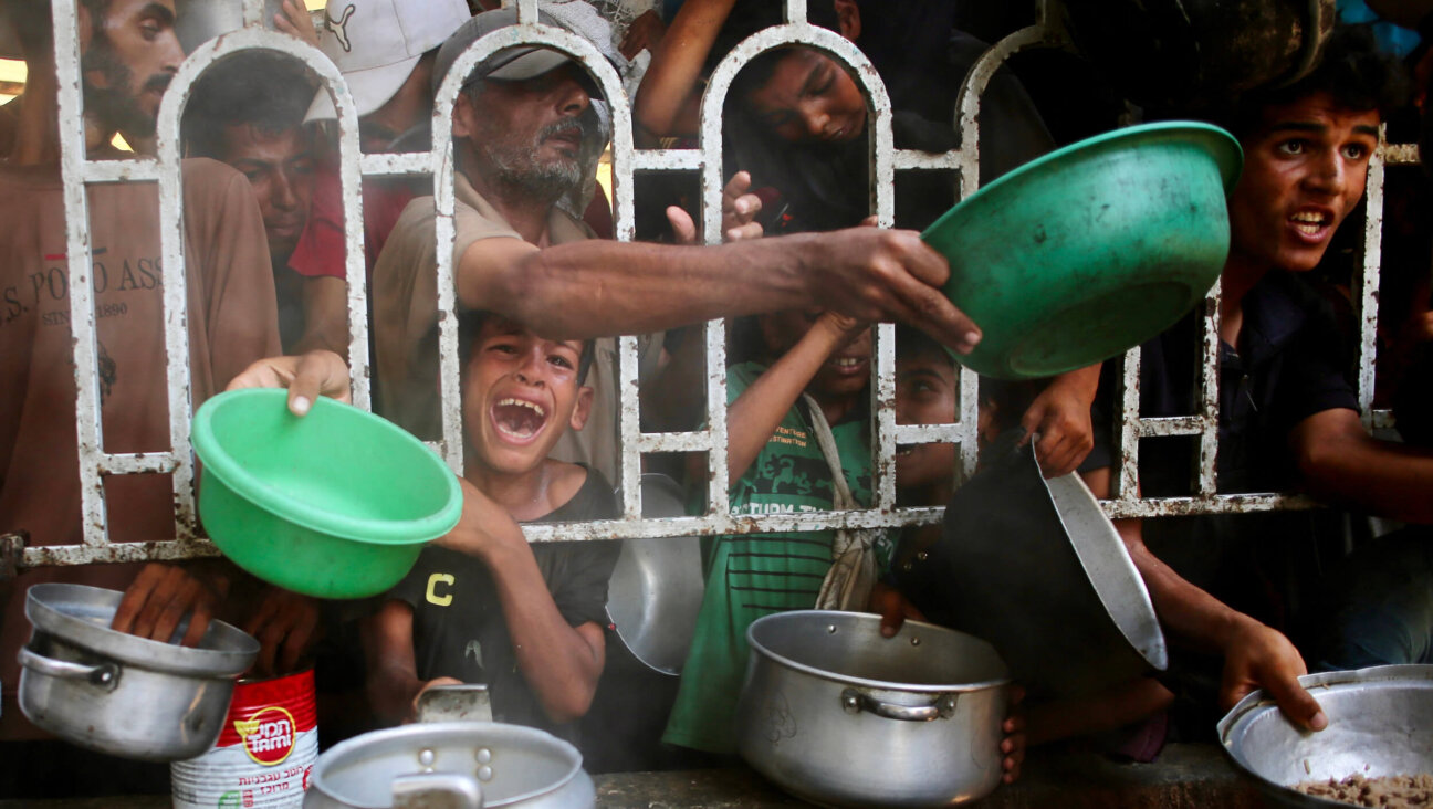 Palestinians struggle to receive a hot meal at a charity kitchen in Khan Younis in Gaza on July 22.