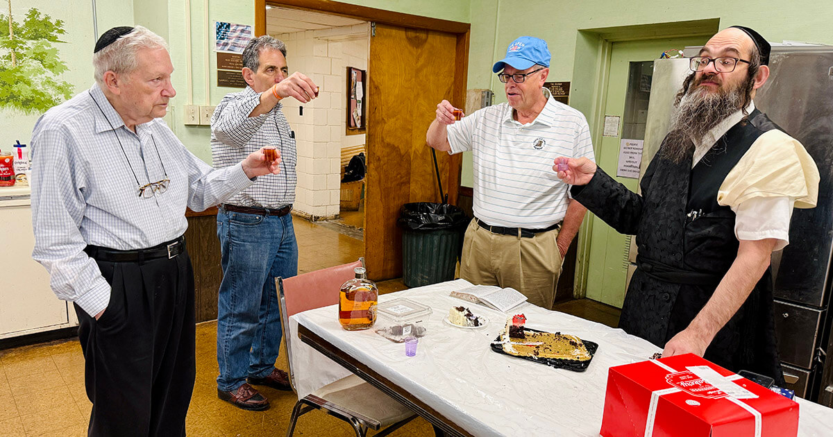 Left to right: Alan Balsam, Alan Iszauk, Bruce Gelman and Yossie Hirsch drink a shot of whiskey after morning prayers, a century-old tradition at Gemilas Chesed synagogue.