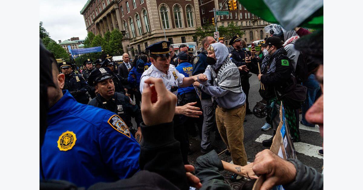A protester is pulled by a police officer during a pro-Palestinian demonstration outside Columbia University's commencement ceremony.  