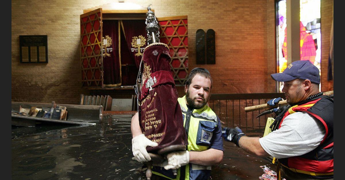 Rabbi Isaac Leider from the Jewish Zaka volunteers carries a Torah scroll out of the flooded synagogue of Beth Israel in New Orleans in September 2005. 