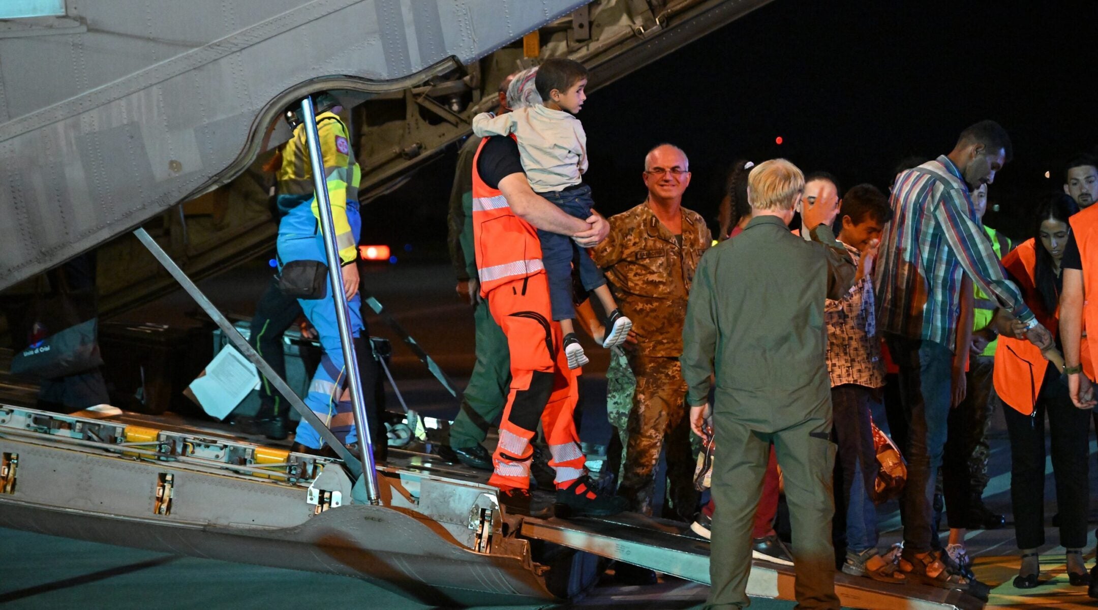 Medics and health personnel welcome Palestinian children from Gaza and their families, after an Italian military plane from Israel landed in Rome in the largest medical evacuation operation since January 2024, on Aug. 14, 2025.