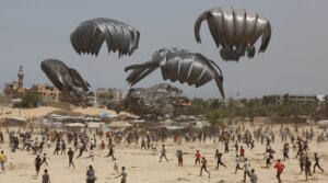 Gazans flock to the area where humanitarian aid is dropped from the air in Deir al Balah on Aug. 19, 2025.