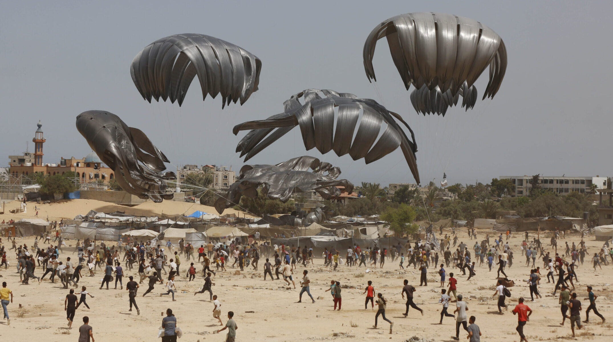 Gazans flock to the area where humanitarian aid is dropped from the air in Deir al Balah on Aug. 19, 2025.
