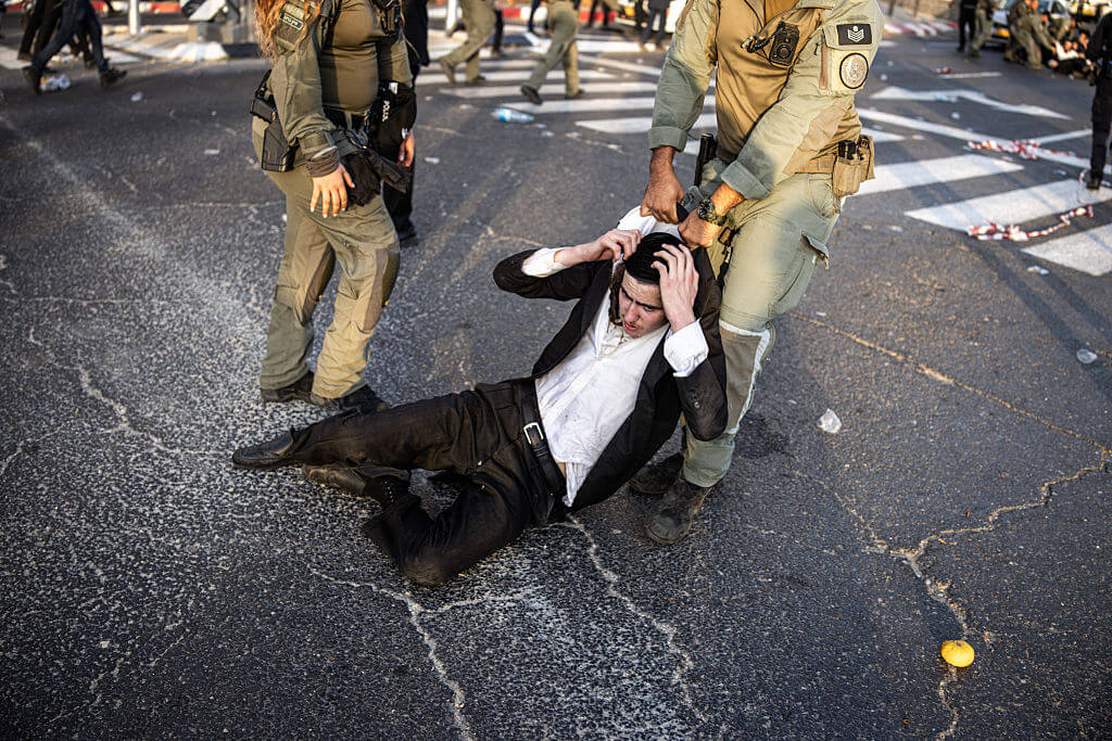A Haredi man is dragged by Israeli security forces during a protest against Israeli army conscription in Kfar Yona on August 19, 2025.