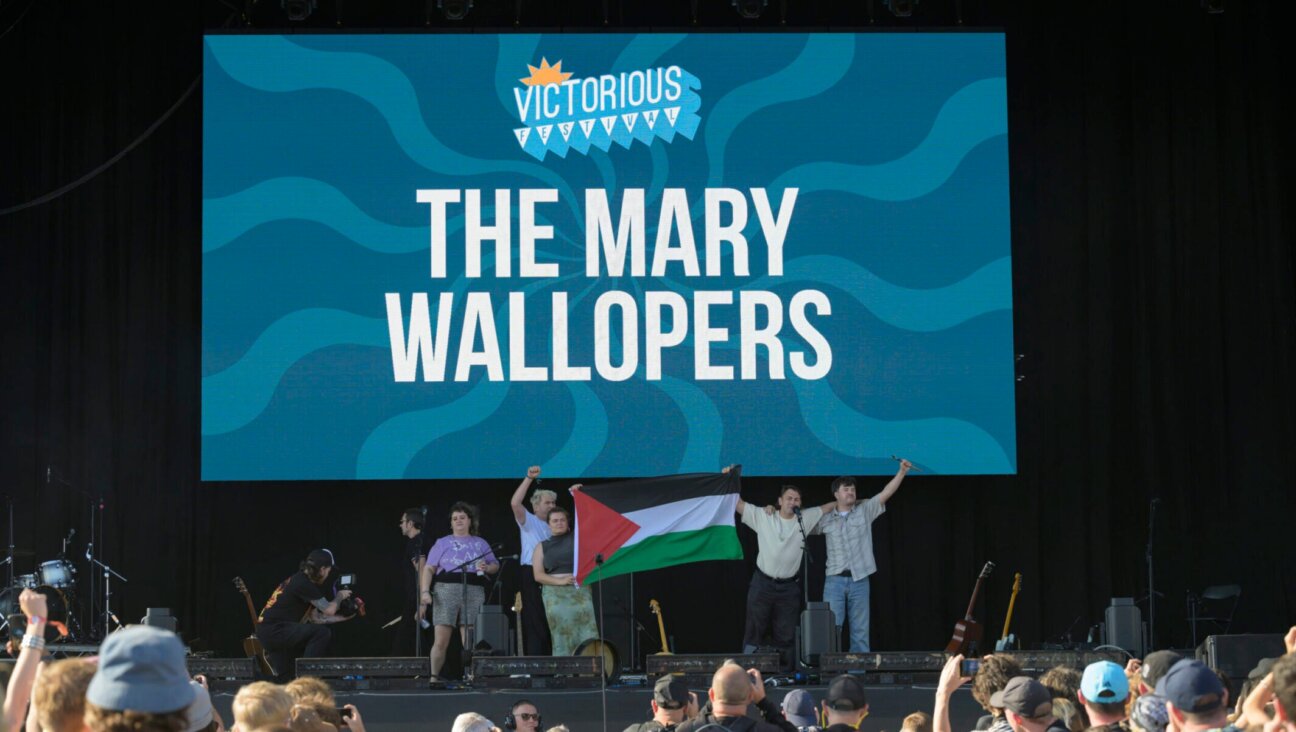 Róisín “Mary” Barrett, Charles Hendy, Andrew Hendy and Ken Mooney of The Mary Wallopers wave a Palestinian flag on the stage of the Victorious festival after their microphones were cut, Aug. 22, 2025 in Southsea, England.