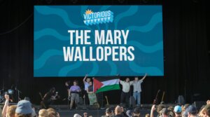 Róisín “Mary” Barrett, Charles Hendy, Andrew Hendy and Ken Mooney of The Mary Wallopers wave a Palestinian flag on the stage of the Victorious festival after their microphones were cut, Aug. 22, 2025 in Southsea, England.