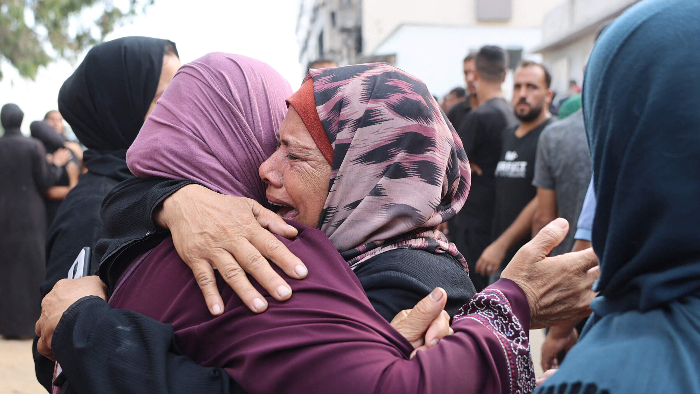 Palestinians mourn relatives, killed in Israeli strikes, ahead of their funeral at Al-Shifa hospital in Gaza City on Aug. 21.