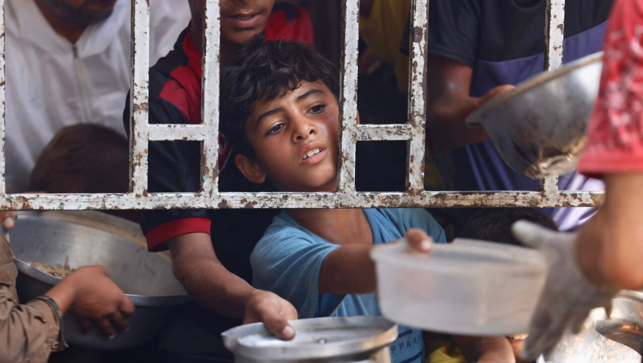 A Palestinian boy seeks a cooked meal at a charity kitchen in the Mawasi area of Khan Yunis in the southern Gaza Strip on July 22.