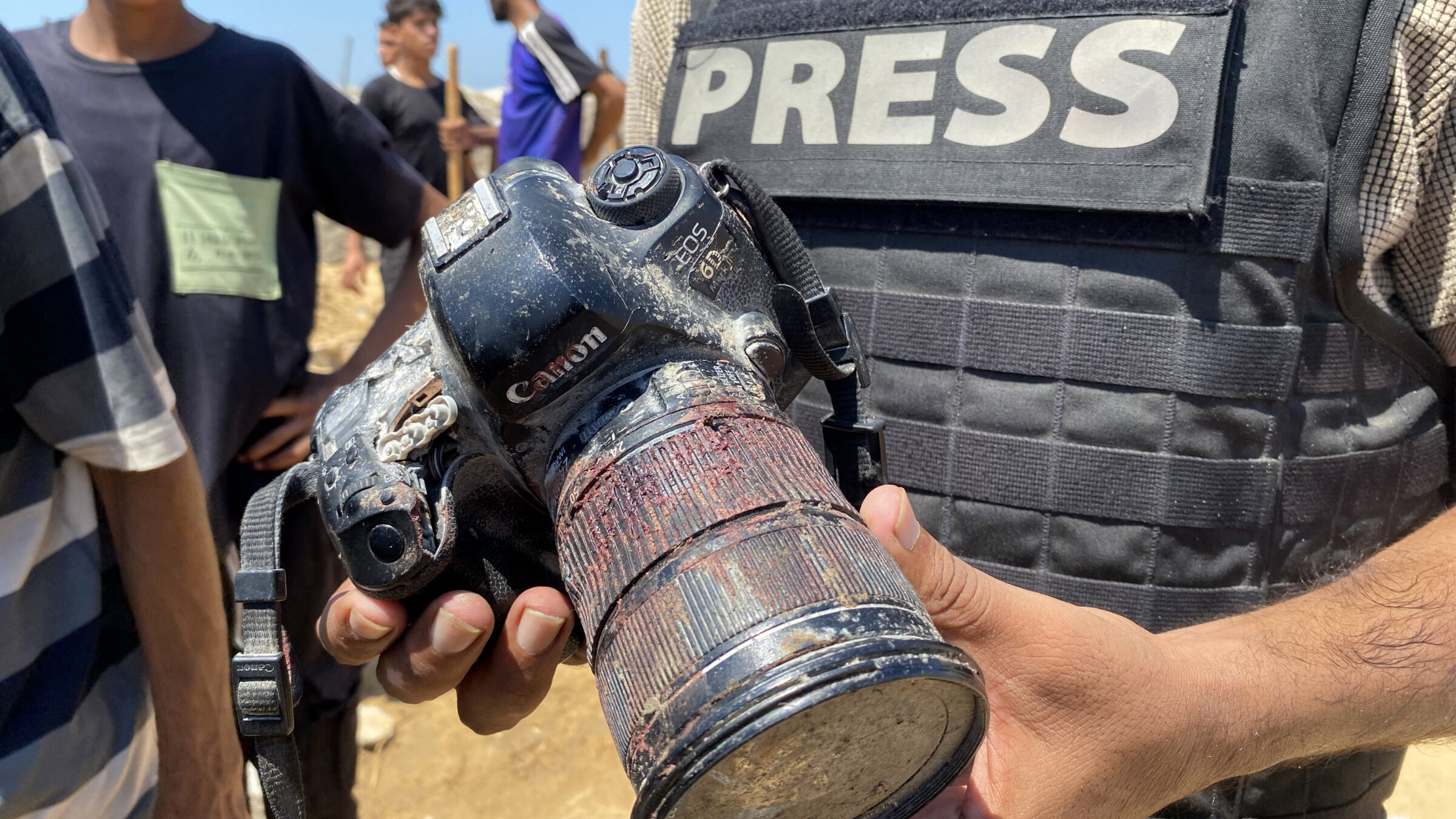 A journalist holds the blood-covered camera belonging to Palestinian photojournalist Mariam Dagga, a journalist who freelanced for AP who was killed in an Israeli strike on Nasser Hospital in Gaza, Aug. 25.