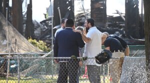 Rabbi Yitzchok Lerman, who survived with his family in the fire that completely destroyed Congregation Beth El synagogue, stands in front of the synagogue’s ruins in Rutherford, New Jersey on August 8.