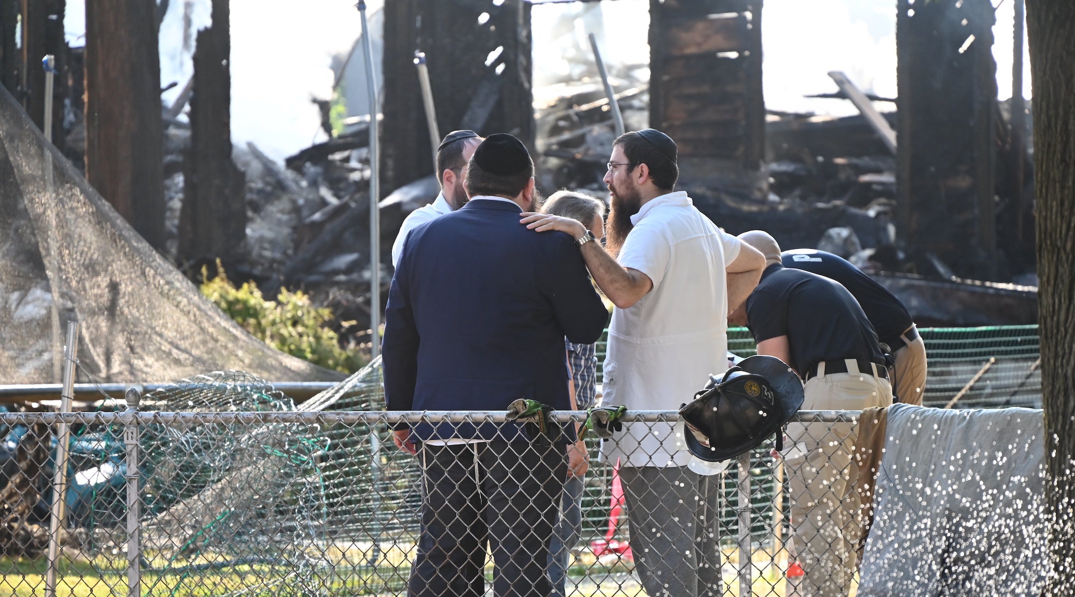 Rabbi Yitzchok Lerman, who survived with his family in the fire that completely destroyed Congregation Beth El synagogue, stands in front of the synagogue’s ruins in Rutherford, New Jersey on August 8.