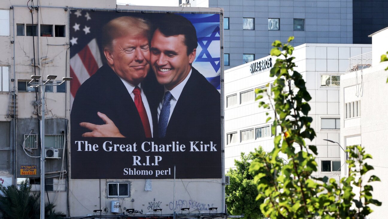 A billboard showing an image of US President Donald Trump (L) embracing US prominent right-wing activist Charlie Kirk, who was hit by a single bullet while addressing a large crowd at Utah Valley University in the town of Orem on September 10, hangs on the side of a building in Tel Aviv, on September 13, 2025.