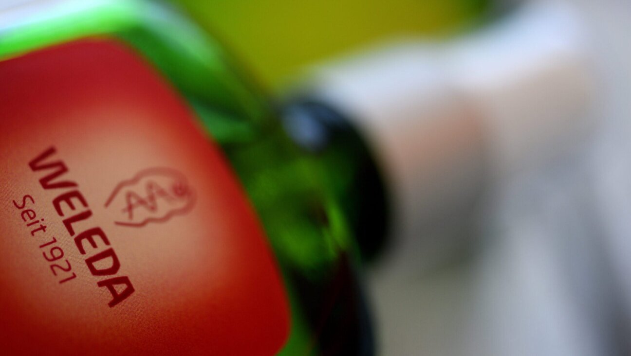 The company logo of Weleda is on a glass bottle. Weleda produces herbal medicines and cosmetics. 