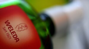 The company logo of Weleda is on a glass bottle. Weleda produces herbal medicines and cosmetics. 