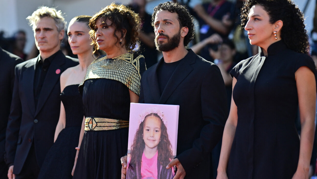 From left: Joaquin Phoenix, Rooney Mara, Kaouther Ben Hania, Motaz Malhees and Clara Khoury pose with a portrait of late Palestinian girl Hind Rajab during the red carpet for the movie "The Voice of Hind Rajab" presented in competition at the 82nd International Venice Film Festival.