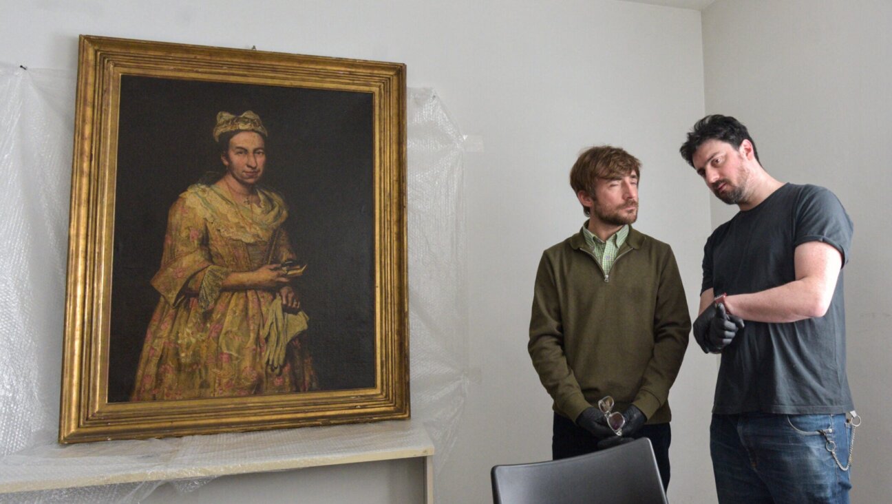 Visual arts teacher Ariel Bassano (L) stands next to a painting identified by Dutch newspaper AD as believed to be “Portrait of a Lady” by Italian baroque portraitist Giuseppe Ghislandi, stolen by the Nazis from a Dutch Jewish art collector, as it is displayed at the Public Prosecutor’s Office in Mar del Plata, Argentina, on Sept. 3, 2025.