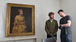Visual arts teacher Ariel Bassano (L) stands next to a painting identified by Dutch newspaper AD as believed to be “Portrait of a Lady” by Italian baroque portraitist Giuseppe Ghislandi, stolen by the Nazis from a Dutch Jewish art collector, as it is displayed at the Public Prosecutor’s Office in Mar del Plata, Argentina, on Sept. 3, 2025.