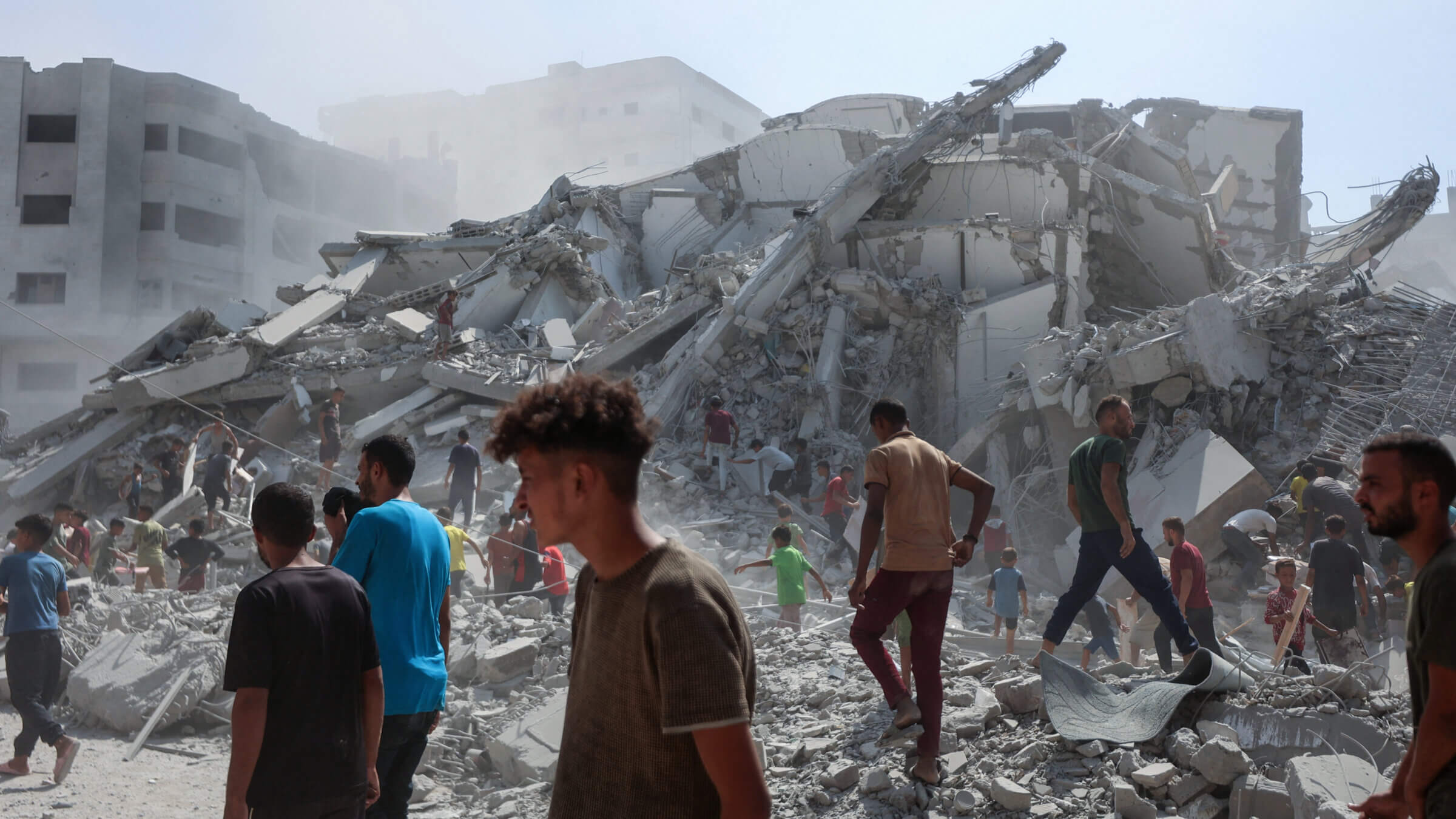 Palestinians search the rubble of al-Ghafari tower after its destruction by Israeli airstrikes in Gaza City on September 15, 2025.