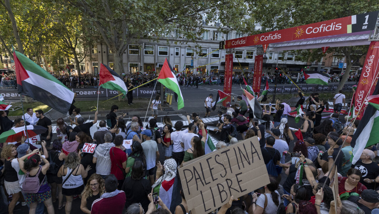 Pro-Palestinian protesters invade the circuit of La Vuelta race as one holds a placard reading 'Free Palestine' in the center of Madrid on Sept. 14