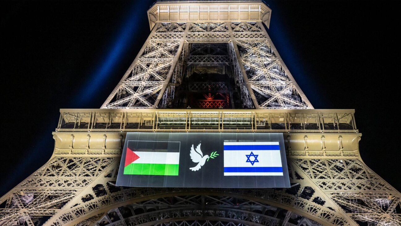 Images of the Palestinian (L) and Israeli (R) flag and a dove with an olive olive branch are projected onto the Eiffel Tower on the eve of France’s planned recognition of the State of Palestine, in Paris, on Sept. 21, 2025. 