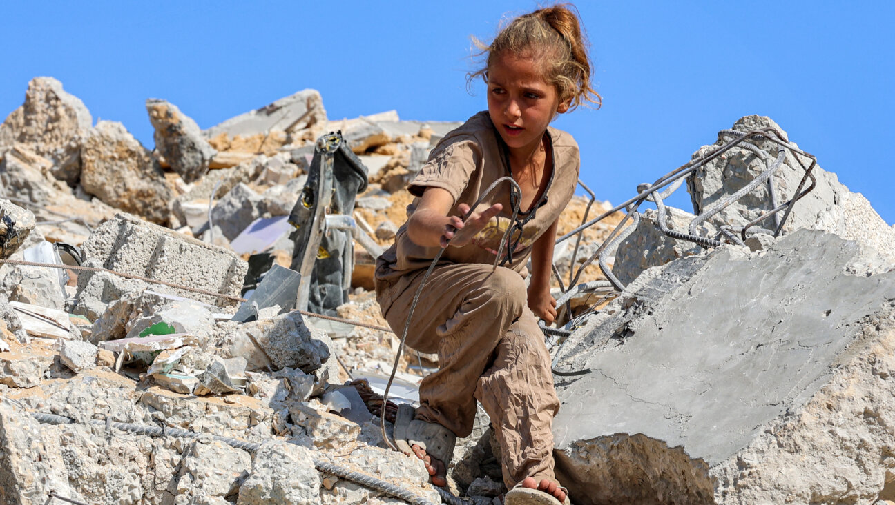 A Palestinian girl searches for salvage in the rubble of a bombed high rise building, Gaza City, Sept. 6.