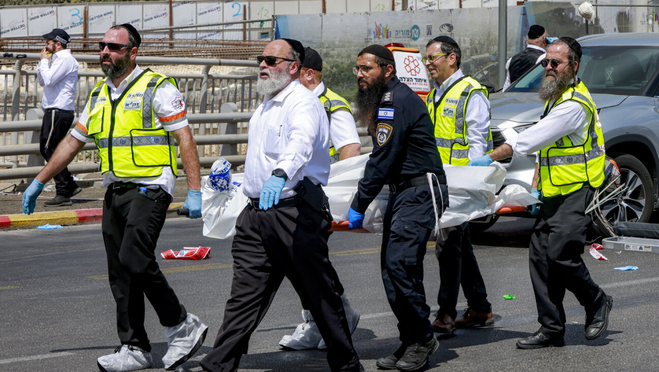 Members of Israel's search and rescue emergency services transport a body from the scene of a shooting at the Ramot road junction in Jerusalem, Sept. 8.