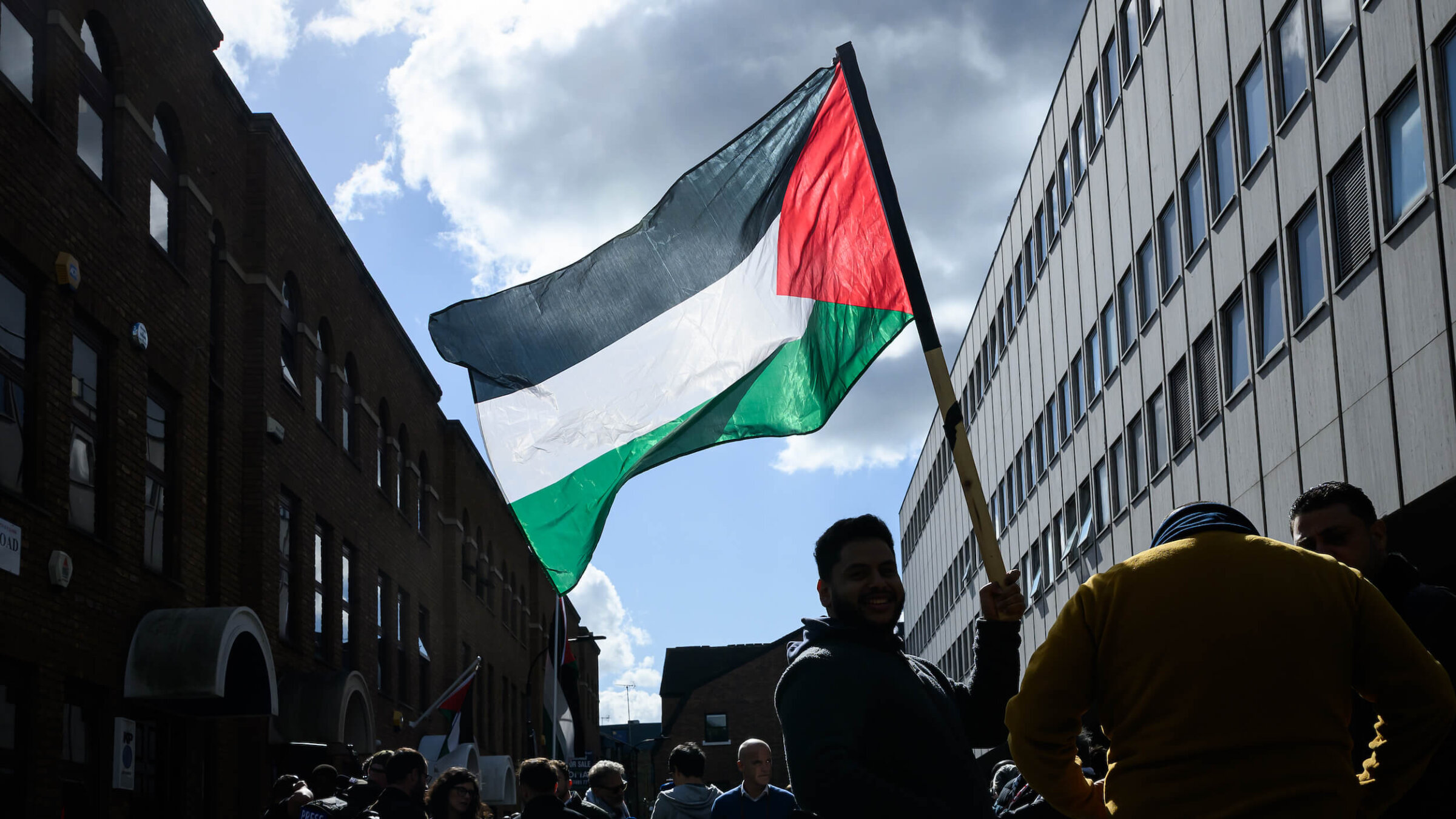 A man holds a Palestinian flag outside the Palestine Mission to the United Kingdom in London on Sept. 22.
