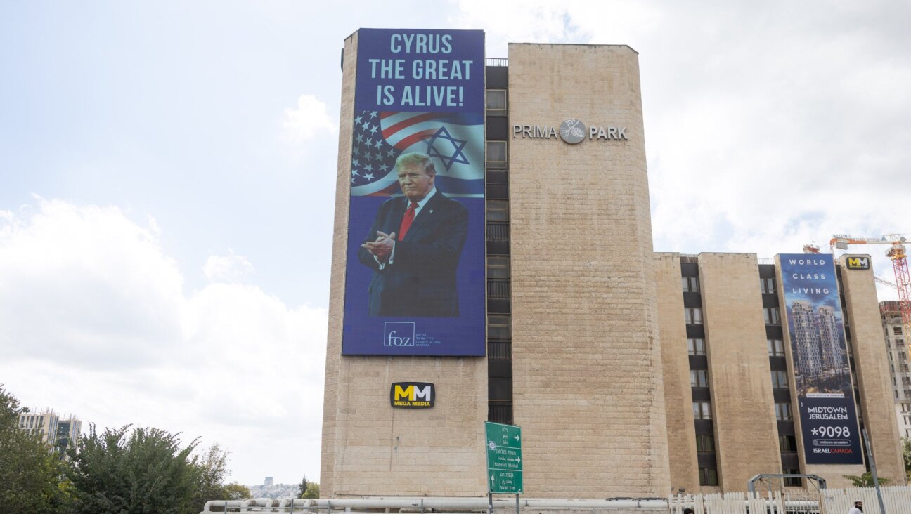 People walk next to a sign honouring U.S. President Donald Trump, in central Jerusalem, October 10, 2025. 
