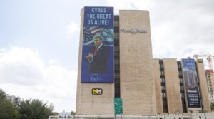 People walk next to a sign honouring U.S. President Donald Trump, in central Jerusalem, October 10, 2025. 