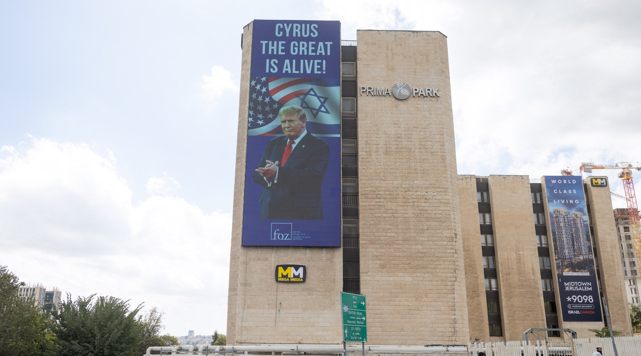 People walk next to a sign honouring U.S. President Donald Trump, in central Jerusalem, October 10, 2025.