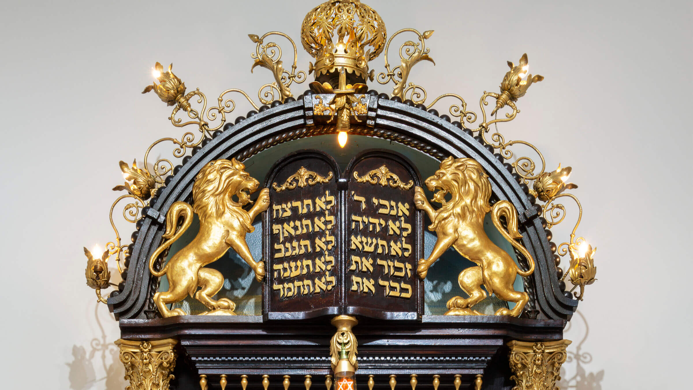 The top of Sam Katz's wooden Torah ark, featuring a pair of golden lions and a Torah crown