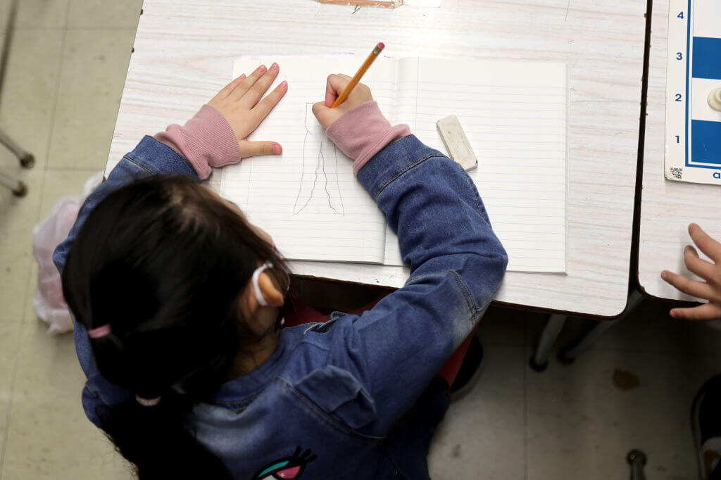 A student draws on a piece of paper at Yung Wing School P.S. 124 on June 24, 2022 in New York City.