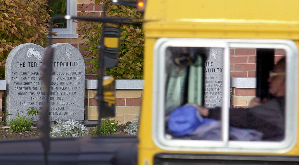 A school bus makes its way past a marker depicting the Ten Commandments outside of Peebles High School  in Ohio in 2002.