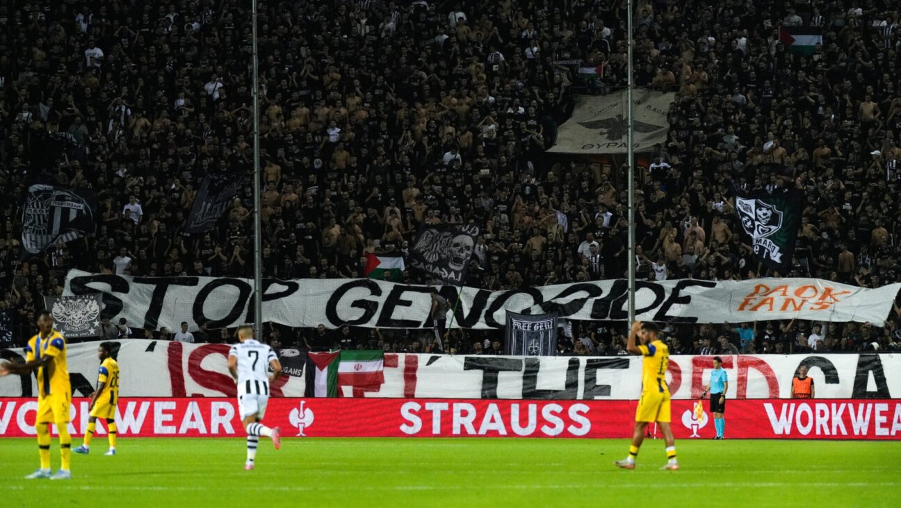Fans raise a banner that reads "Stop Genocide — Show Israel the Red Card" during a September football match between PAOK and Maccabi Tel Aviv in Greece.
