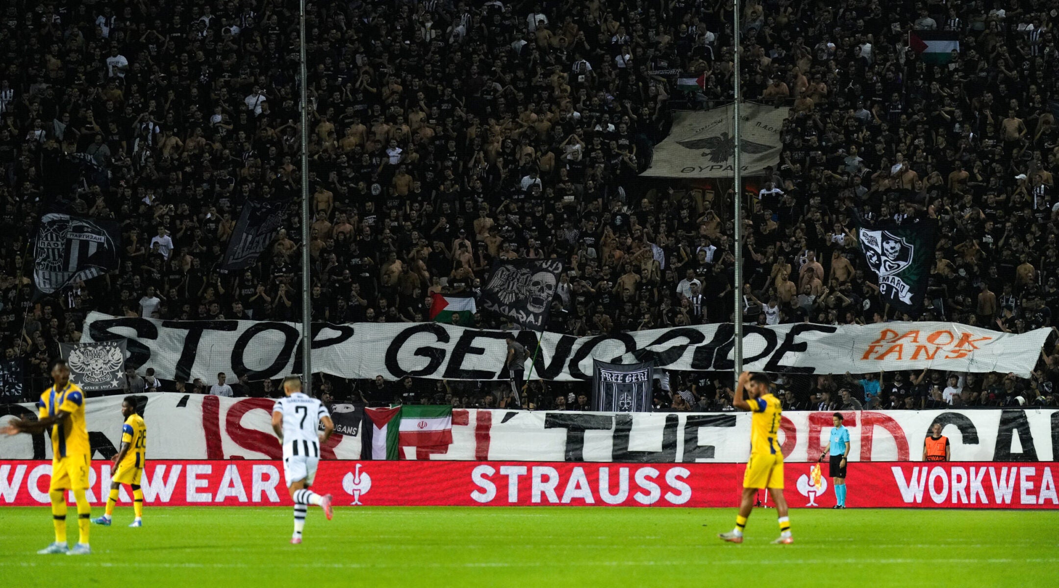 Fans raise a banner that reads "Stop Genocide — Show Israel the Red Card" during a September football match between PAOK and Maccabi Tel Aviv in Greece.