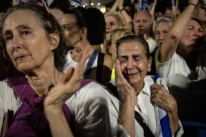 A woman reacts while listening to speeches by family members of hostages during a solidarity protest in Tel Aviv on October 4.