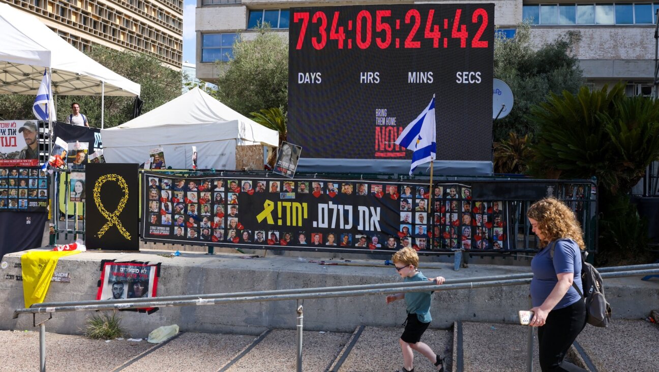 A woman and a child walk past posters of hostages held by the Palestinian militant group Hamas in Gaza at Hostage Square in Tel Aviv on Oct. 10, 2025.