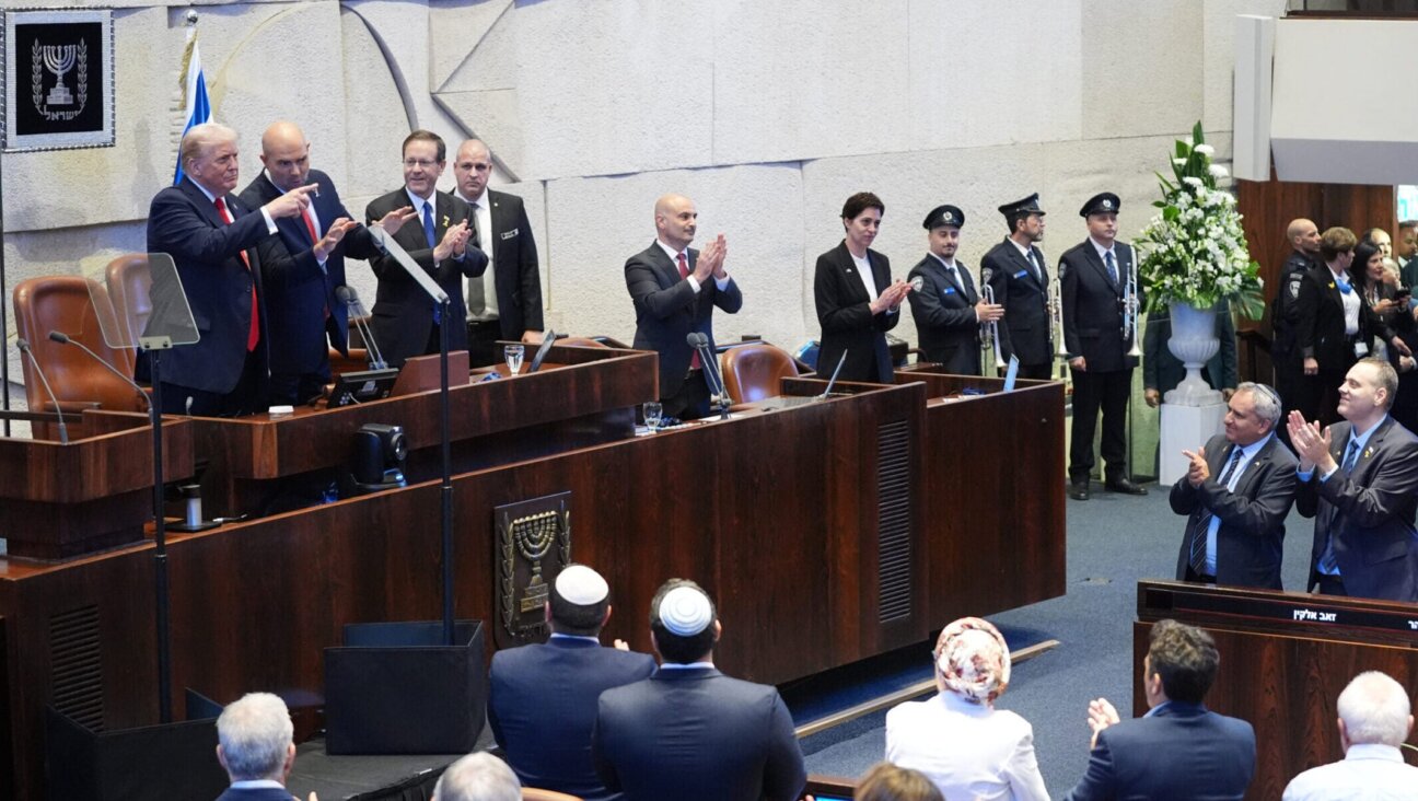 U.S. President Donald Trump arrives with Knesset Speaker Amir Ohana and Israel’s President Isaac Herzog to speak to the Knesset, Israel’s parliament, on Oct. 13, 2025 in Jerusalem. 