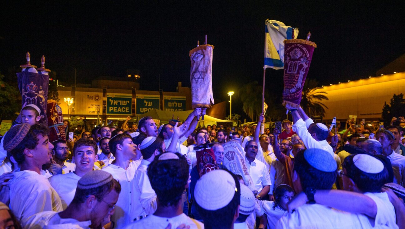 People dance around worshipers holding Torahs during the “hakafot” ritual of Simchat Torah in Hostages Square in Tel Aviv, Oct. 14, 2025. 