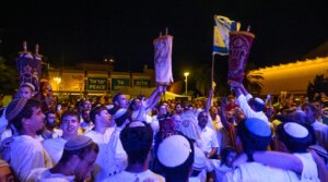 People dance around worshipers holding Torahs during the “hakafot” ritual of Simchat Torah in Hostages Square in Tel Aviv, Oct. 14, 2025. 