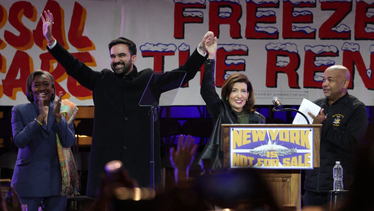 New York City mayoral candidate Zohran Mamdani holds hands with Gov. Kathy Hochul on stage during a campaign rally at Forest Hills Stadium in Queens, Oct. 26, 2025.