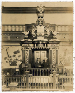 Sam Katz (right) with Torah ark at synagogue Anshai Poland, with MFA's Gilded Lion on the right side.