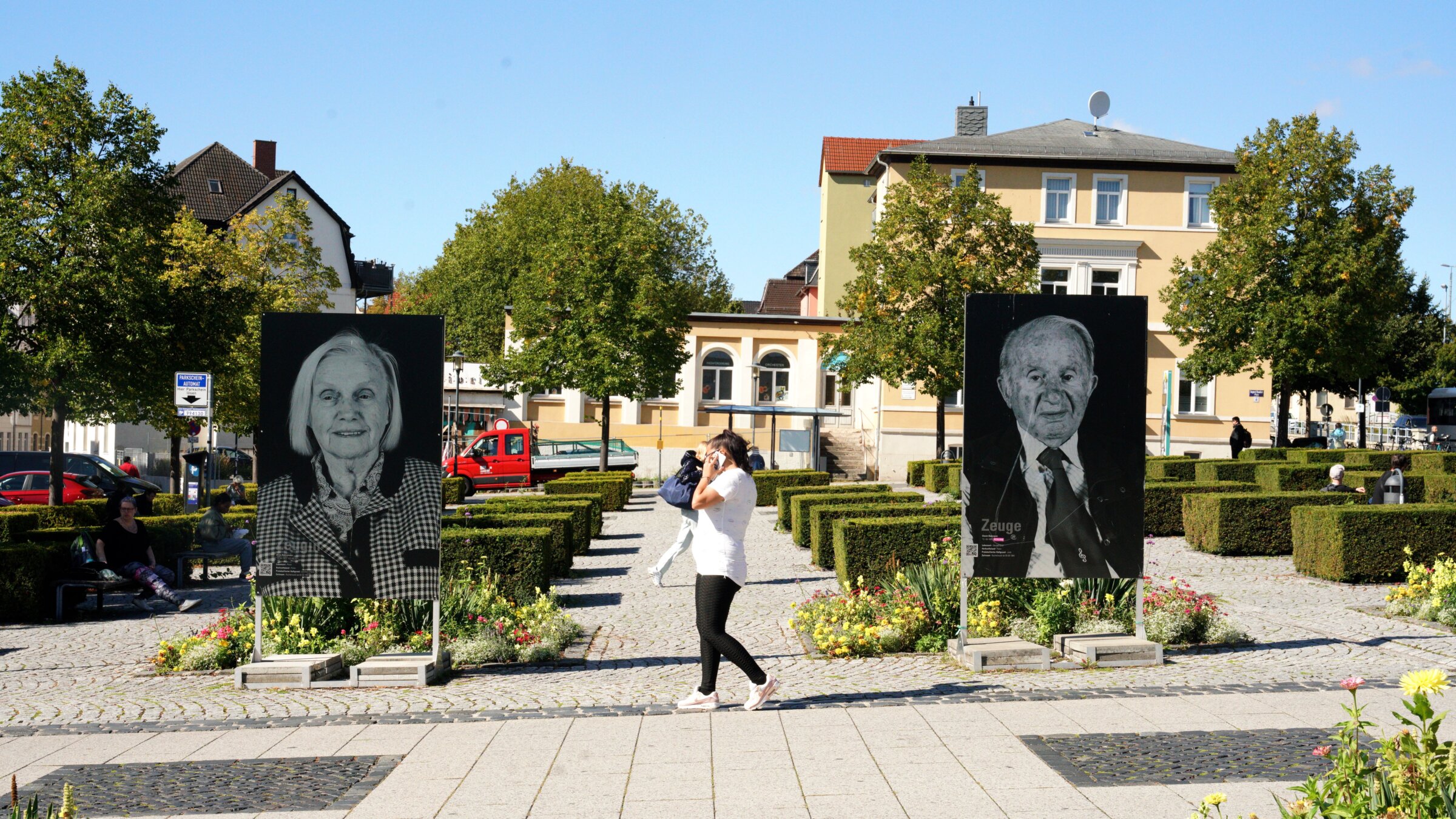 Photos of survivors from Buchenwald by photographer Thomas Müller stand in the square outside of Weimar’s central train station in the public art project “Die Zeugen”.