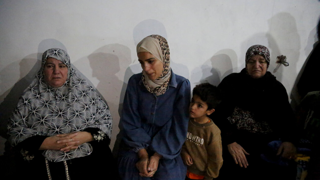 The mother of 10-year-old Mohammed Bahjat Al-Hallaq sits surrounded by relatives in the family home in the village of Al-Rihiyah, south of Hebron, on Oct. 16, after her son was killed by the Israeli army, according to local sources.