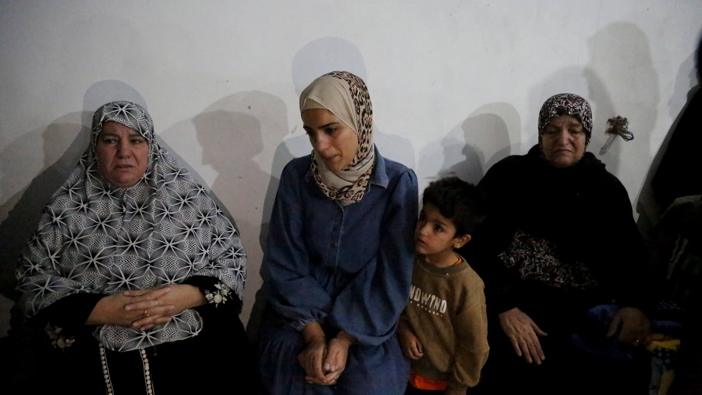 The mother of 10-year-old Mohammed Bahjat Al-Hallaq sits surrounded by relatives in the family home in the village of Al-Rihiyah, south of Hebron, on Oct. 16, after her son was killed by the Israeli army, according to local sources.